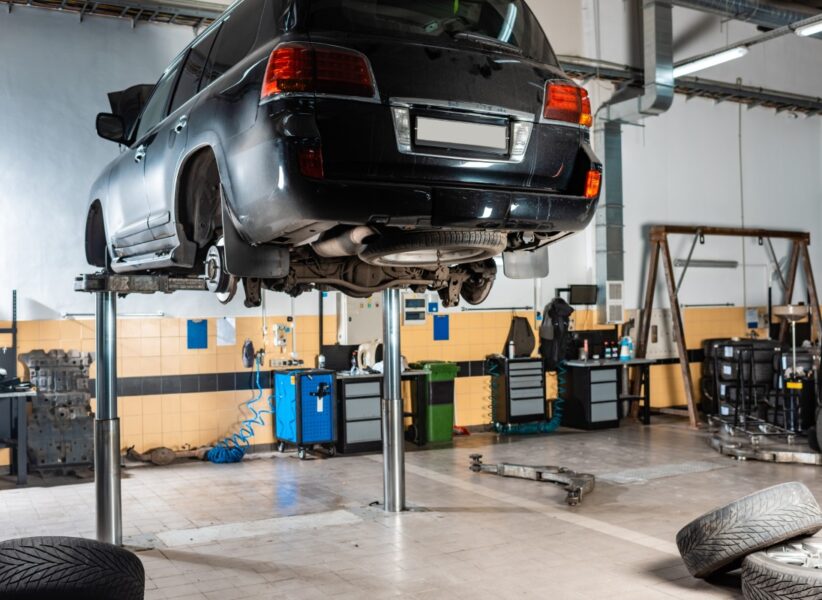modern black car raised on car lift in workshop modern black car raised on car lift in workshop