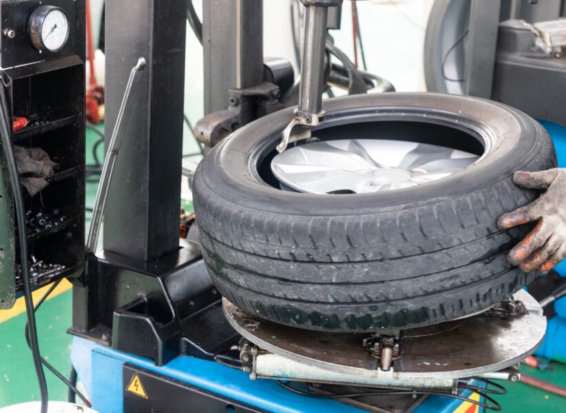 Series of worker removing tire from rim with removal machinery Series of worker removing tire from rim with tire removal machinery equipment