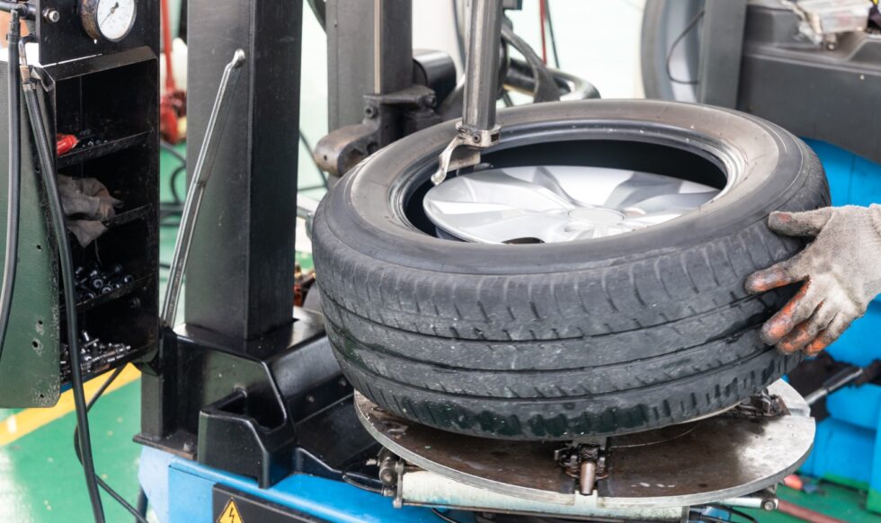 Series of worker removing tire from rim with removal machinery Series of worker removing tire from rim with tire removal machinery equipment